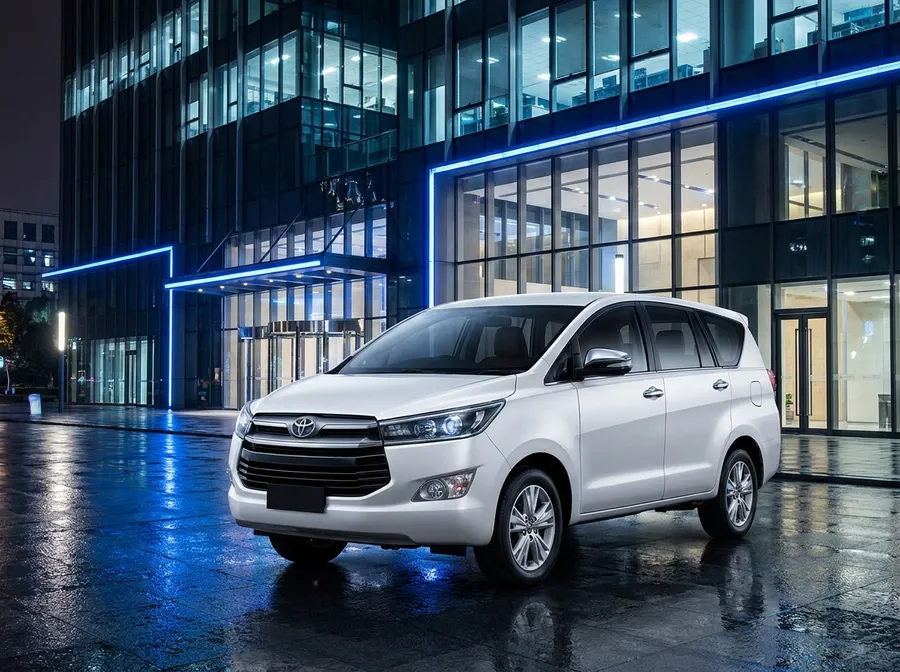 Pearl white Toyota Innova Crysta premium MPV at night
