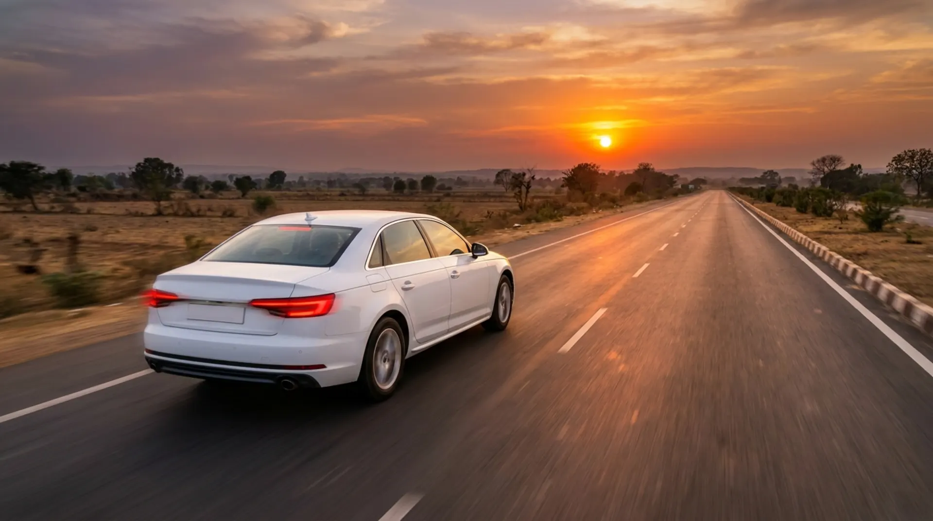White sedan cab driving on an open highway at golden hour